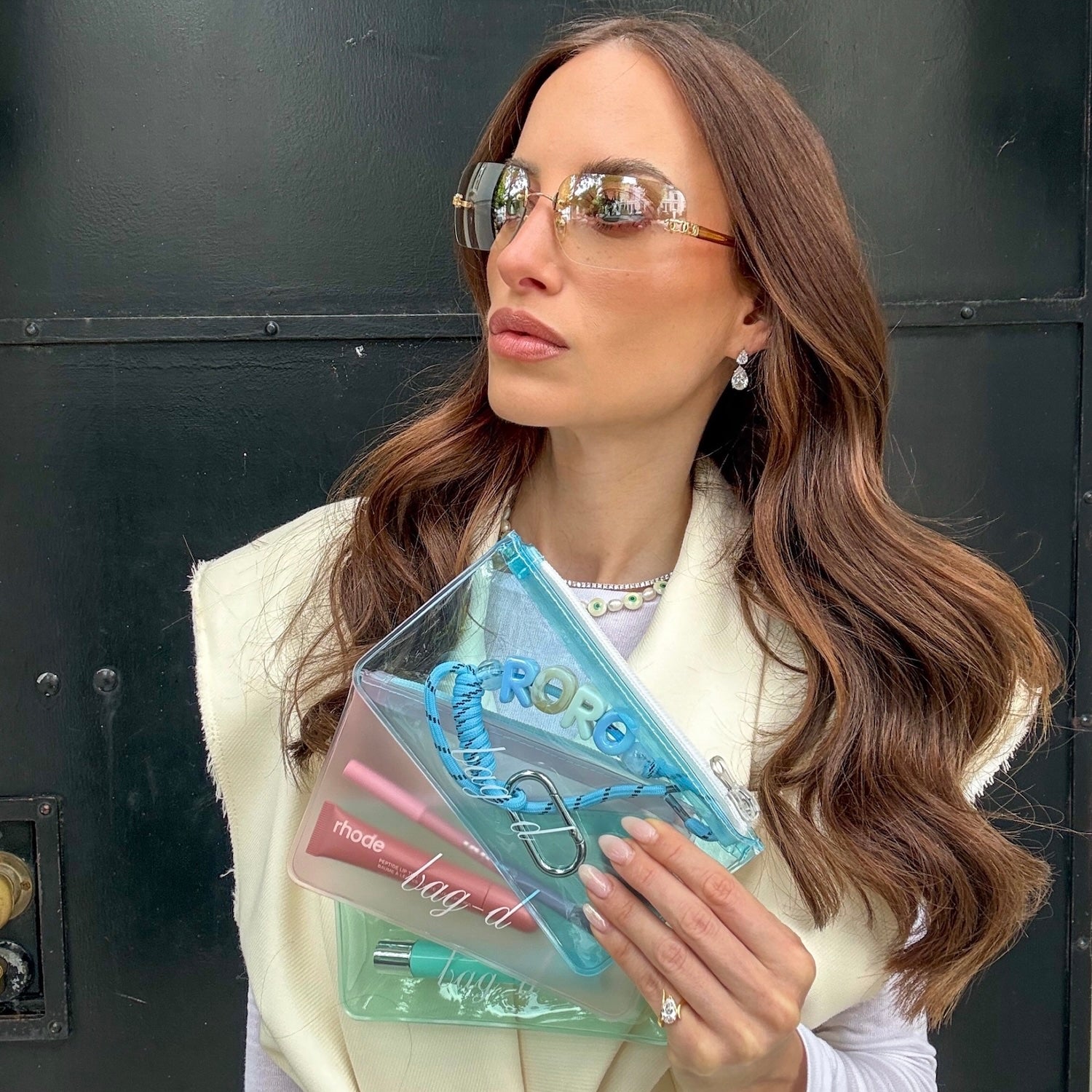 Model holds BAG-D The Everything Pouch  Pastel in frosted TPU